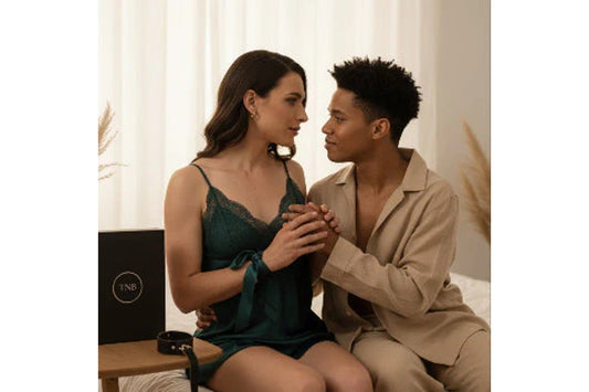 Cuplu trans și non-binar într-un cadru intim, alături de jucării și accesorii sexuale premium, pentru un ghid începător despre plăcere, confort și explorare body-safe.